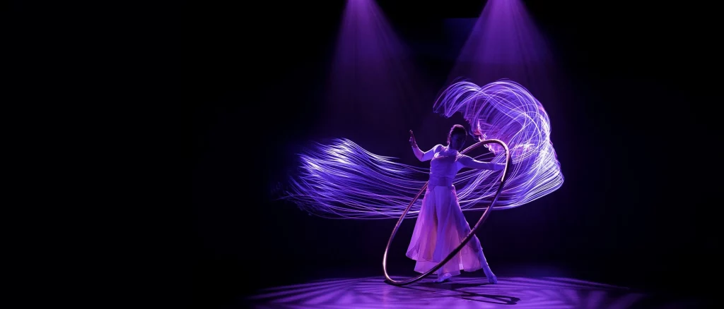 Artista actuando bajo luces en gala corporativa.